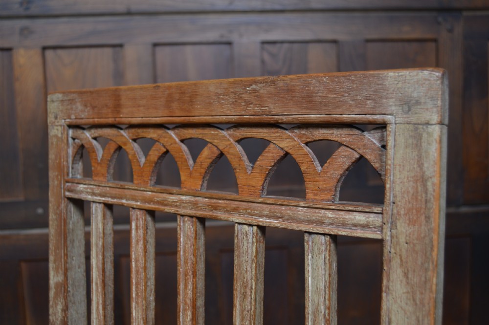 An antique Scottish oak crofter armchair featuring vertical back slats, a carved top rail, exposed wooden pegs, and a woven rush seat. View XIII