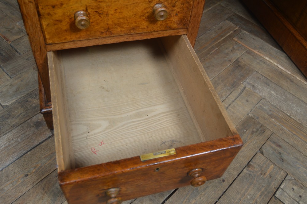 Victorian warm brown oak pedestal writing desk with a green leather inset top, brass gallery rail, and nine drawers. View VII