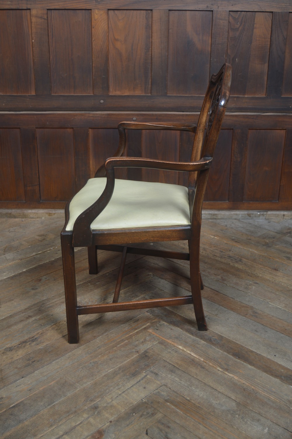 A set of eight dark mahogany Edwardian dining chairs with carved rosette back splats and cream upholstered seats, including two carvers. View XII