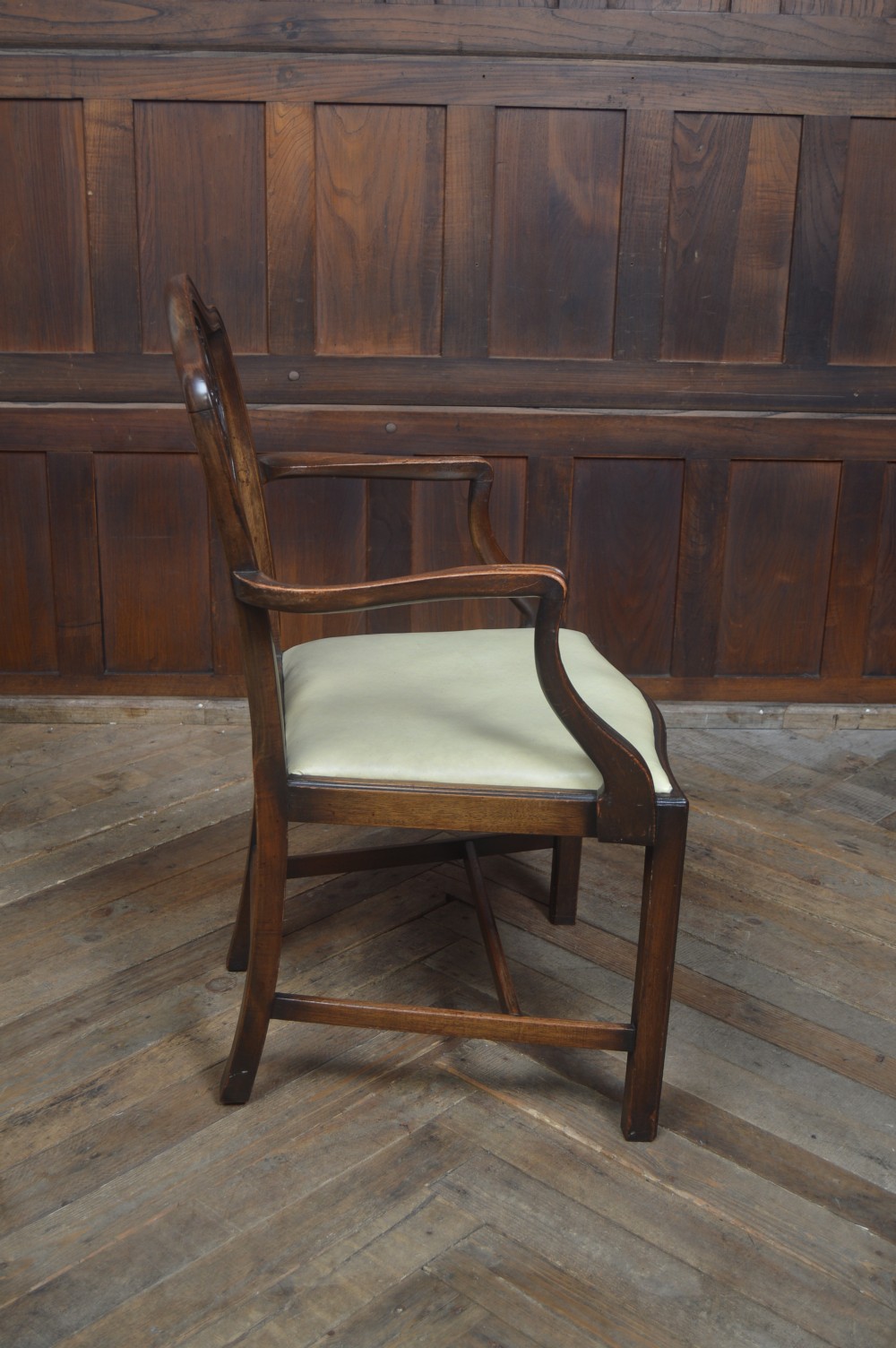 A set of eight dark mahogany Edwardian dining chairs with carved rosette back splats and cream upholstered seats, including two carvers. View XIII