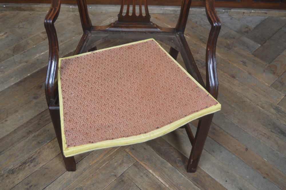 A set of eight dark mahogany Edwardian dining chairs with carved rosette back splats and cream upholstered seats, including two carvers. View XIV