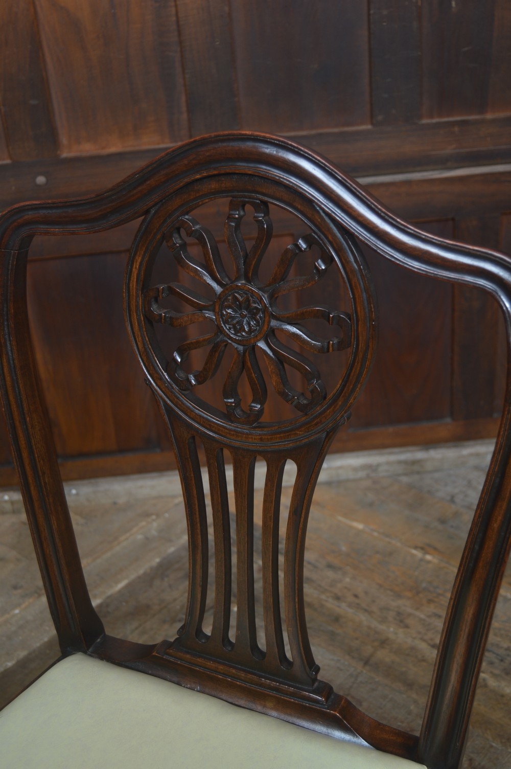 A set of eight dark mahogany Edwardian dining chairs with carved rosette back splats and cream upholstered seats, including two carvers. View XV