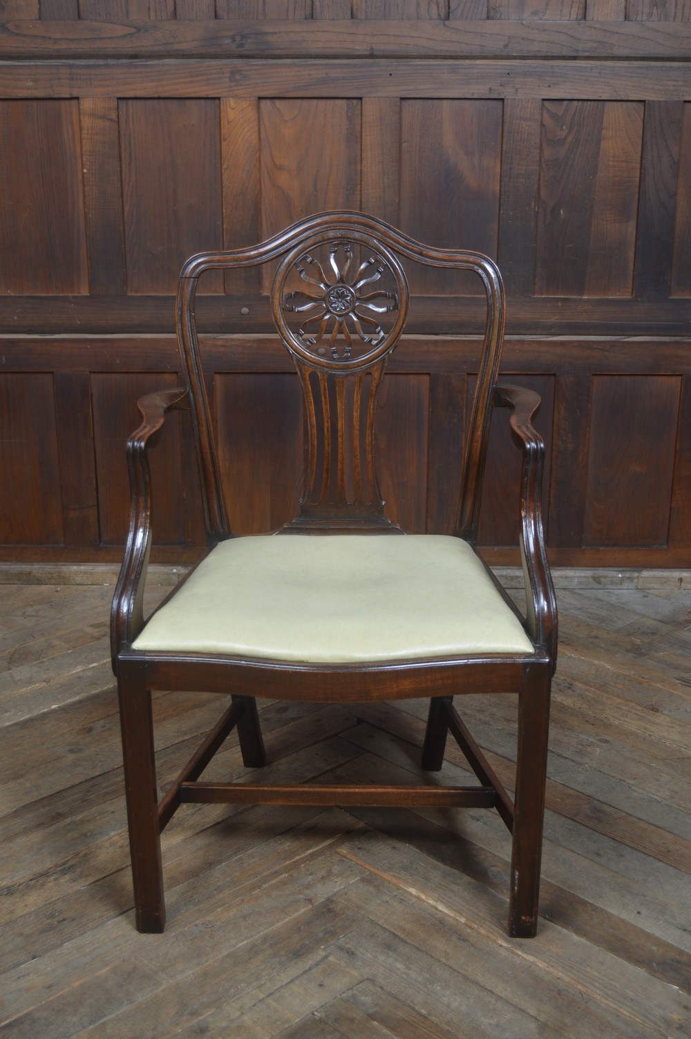 A set of eight dark mahogany Edwardian dining chairs with carved rosette back splats and cream upholstered seats, including two carvers. View XVI