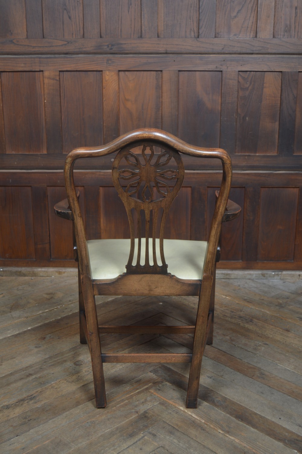 A set of eight dark mahogany Edwardian dining chairs with carved rosette back splats and cream upholstered seats, including two carvers. View XVIII