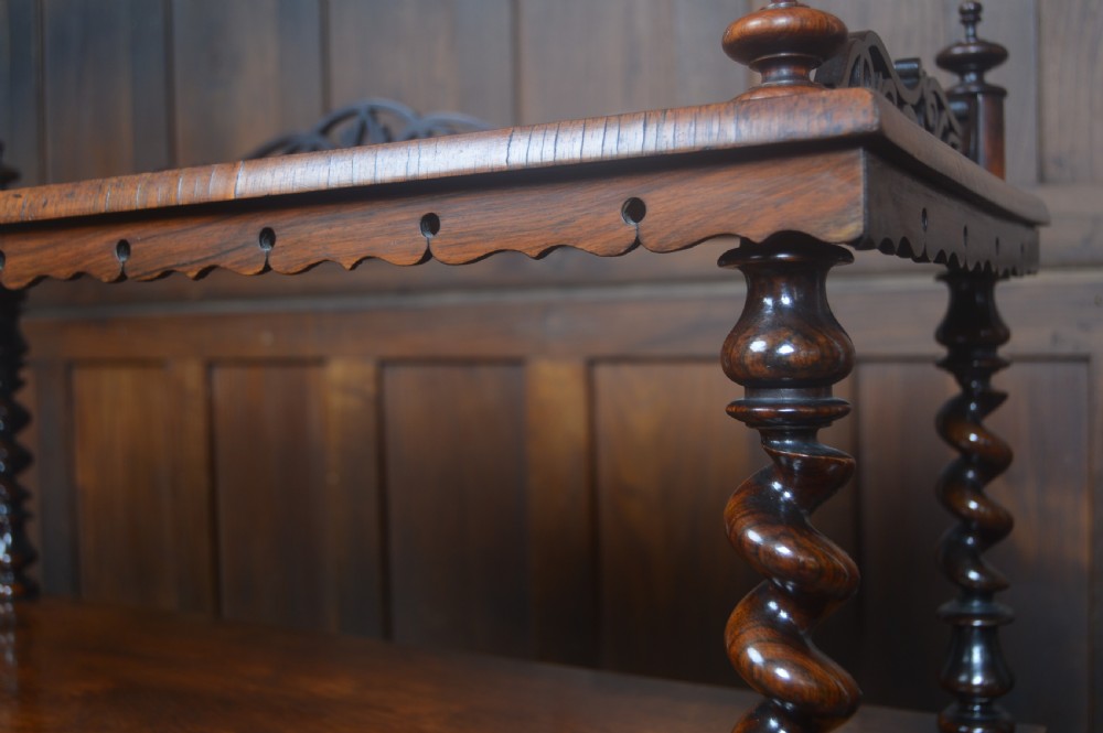 A Victorian rosewood whatnot featuring two open upper shelves supported by barley twist columns, topped with a fretwork gallery, above a lower two-door mirrored cabinet. View VI
