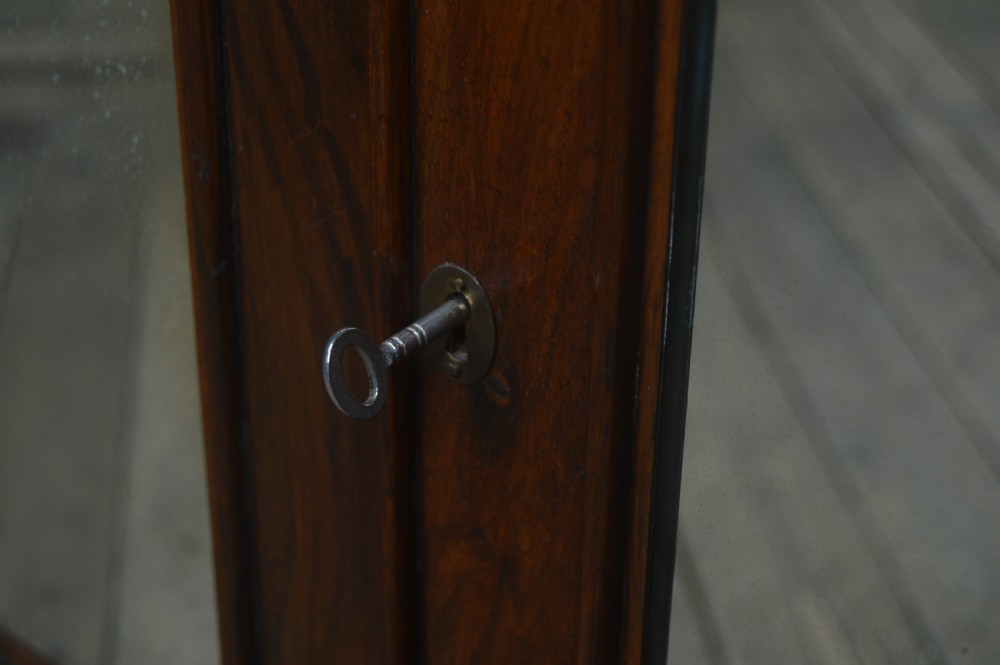 A Victorian rosewood whatnot featuring two open upper shelves supported by barley twist columns, topped with a fretwork gallery, above a lower two-door mirrored cabinet. View VIII