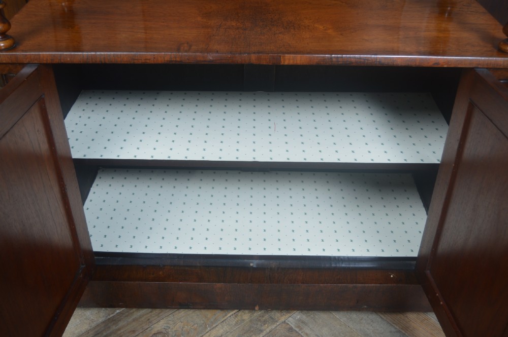 A Victorian rosewood whatnot featuring two open upper shelves supported by barley twist columns, topped with a fretwork gallery, above a lower two-door mirrored cabinet. View IX