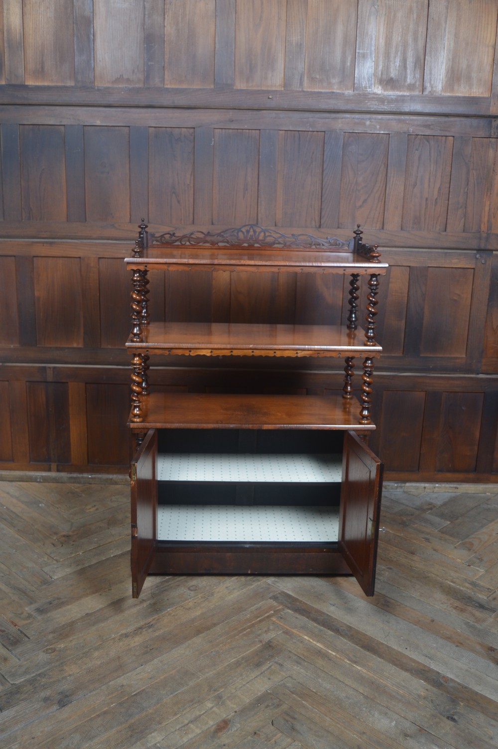 A Victorian rosewood whatnot featuring two open upper shelves supported by barley twist columns, topped with a fretwork gallery, above a lower two-door mirrored cabinet. View XIII