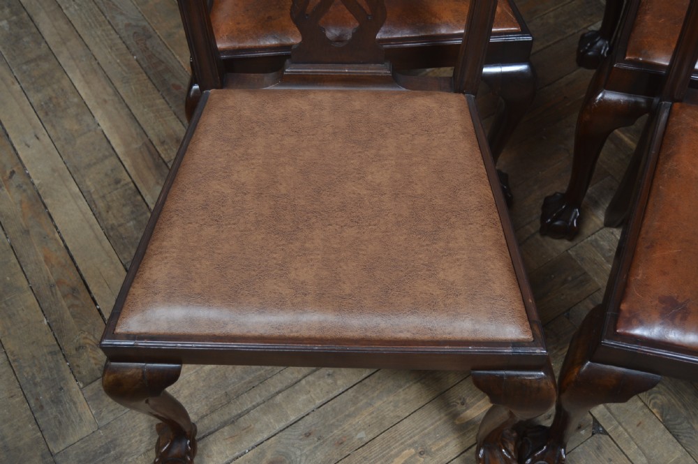 A set of eight dark mahogany Edwardian Chippendale style dining chairs featuring pierced back splats, leather seats, and cabriole legs with ball and claw feet. View V
