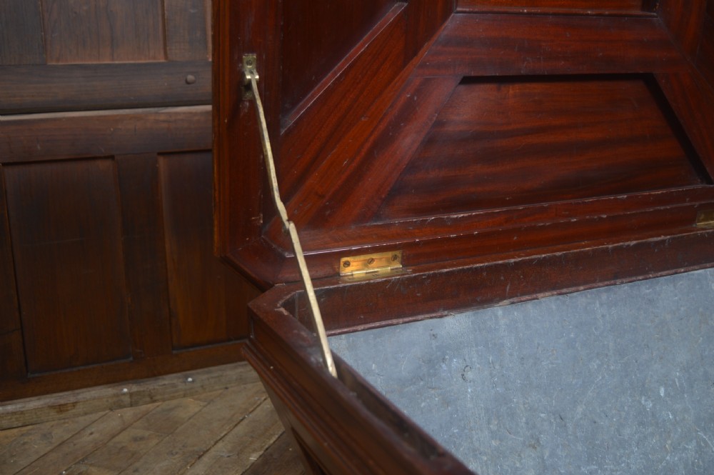 A mahogany sarcophagus-shaped cellarette featuring a tapered wooden body, stepped hinged lid, and carved paw feet. View IX