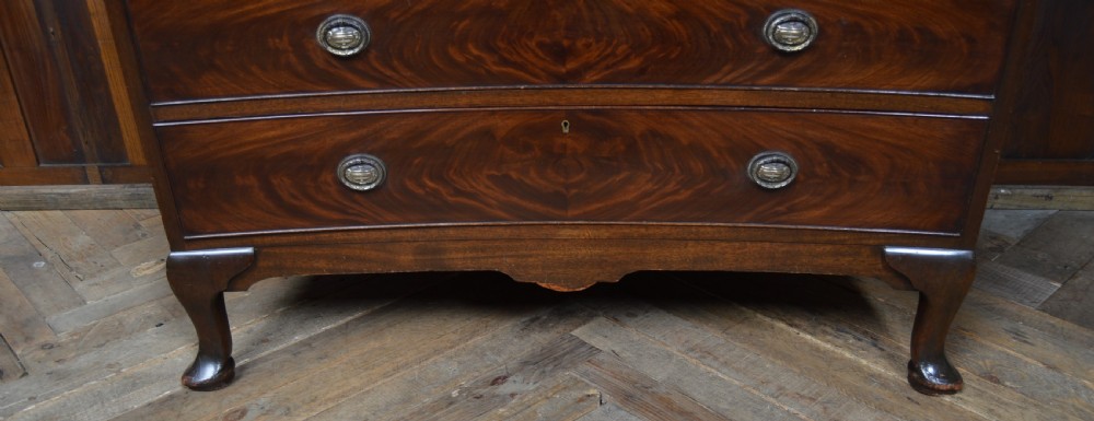 A mahogany chest of drawers featuring flame mahogany drawer fronts, two short over two long drawers, brass handles, and cabriole legs. View XVI