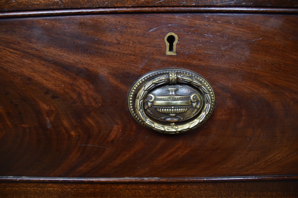 A mahogany chest of drawers featuring flame mahogany drawer fronts, two short over two long drawers, brass handles, and cabriole legs. View XVII