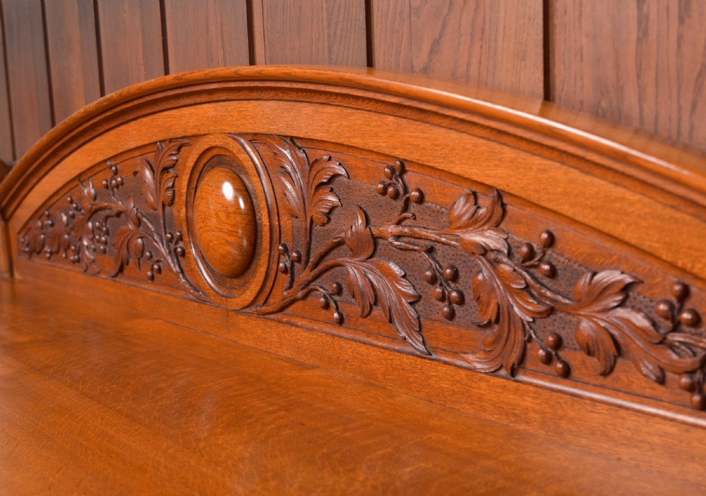 A Victorian oak pedestal sideboard featuring an arched carved backboard with foliage details, twin cupboard pedestals, and a recessed central section. View IV
