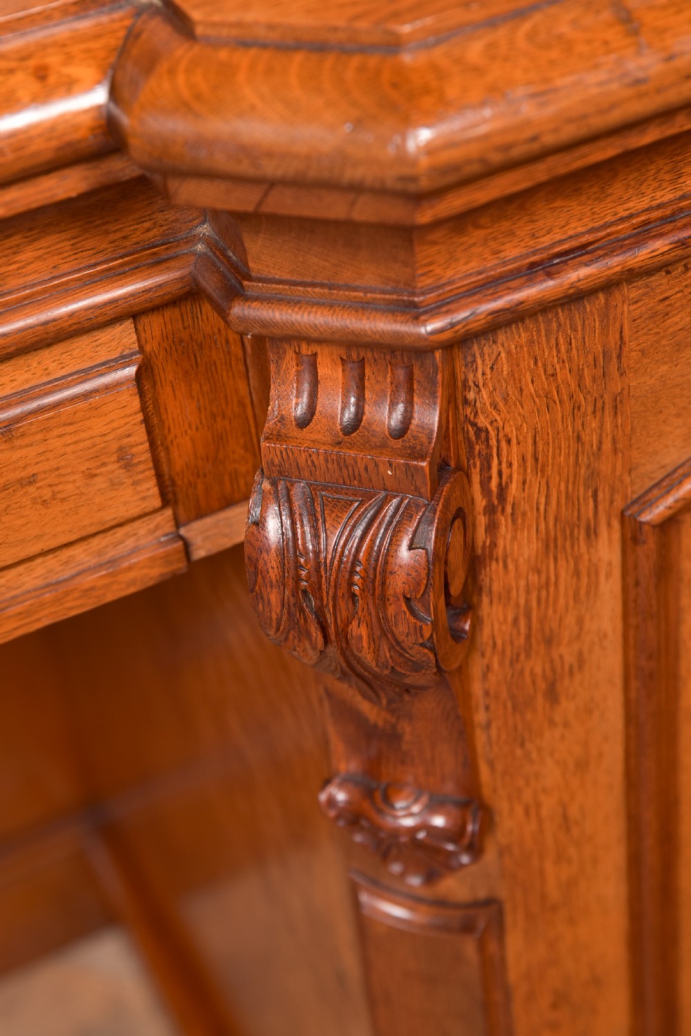A Victorian oak pedestal sideboard featuring an arched carved backboard with foliage details, twin cupboard pedestals, and a recessed central section. View V