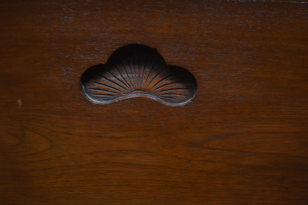 A carved warm brown camphor wood chest featuring a relief dragon motif on the front panel and a decorative circular brass clasp. View XXVI