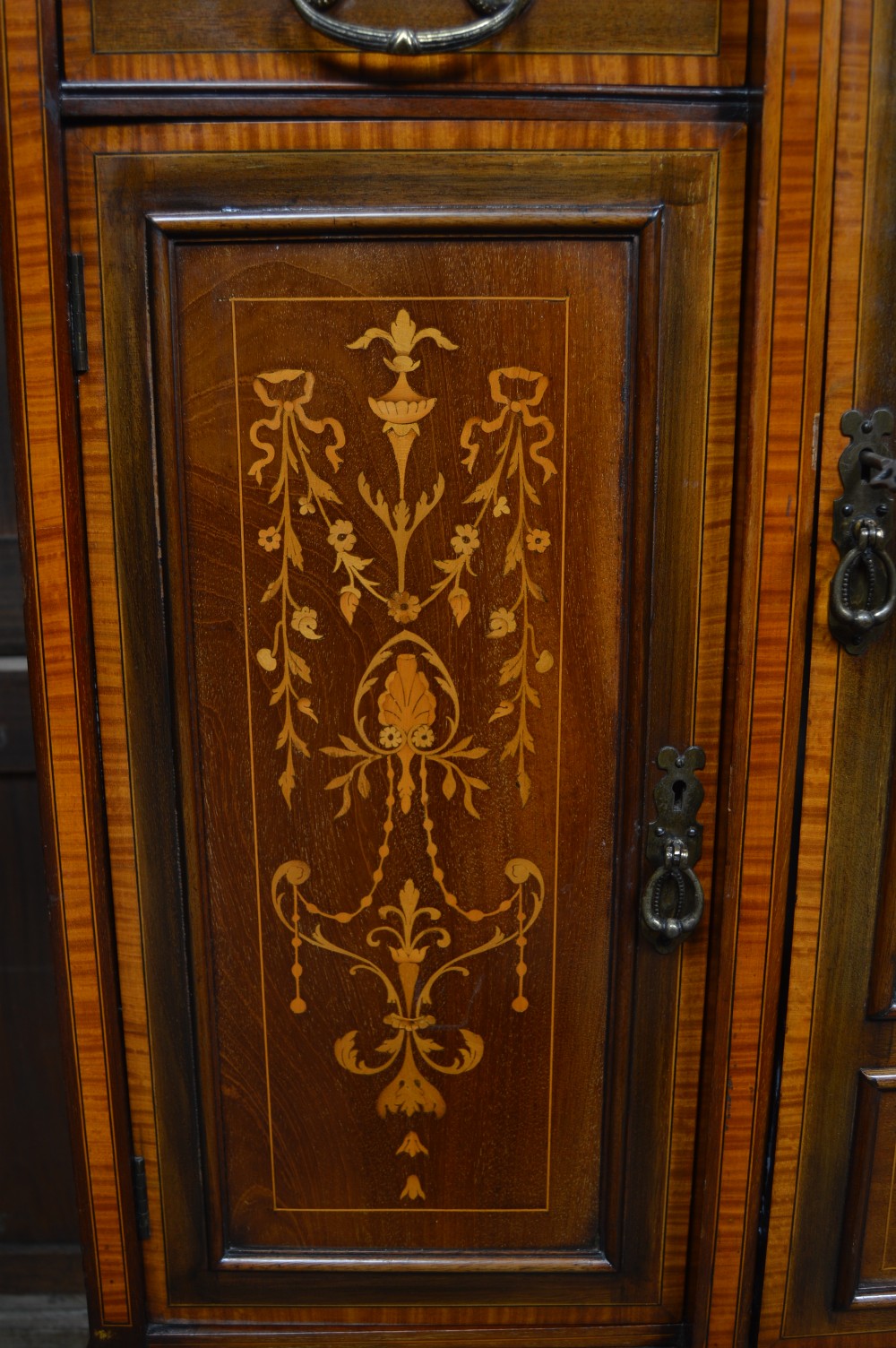 An Edwardian mahogany display cabinet featuring floral marquetry inlay, an oval mirror backdrop, astragal glazed central door, and slender cabriole legs. View VII