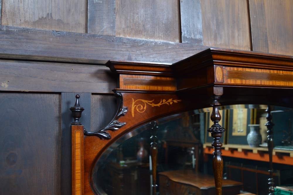 An Edwardian mahogany display cabinet featuring floral marquetry inlay, an oval mirror backdrop, astragal glazed central door, and slender cabriole legs. View VIII