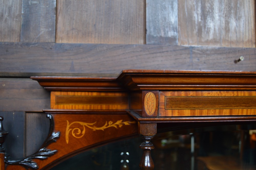 An Edwardian mahogany display cabinet featuring floral marquetry inlay, an oval mirror backdrop, astragal glazed central door, and slender cabriole legs. View IX