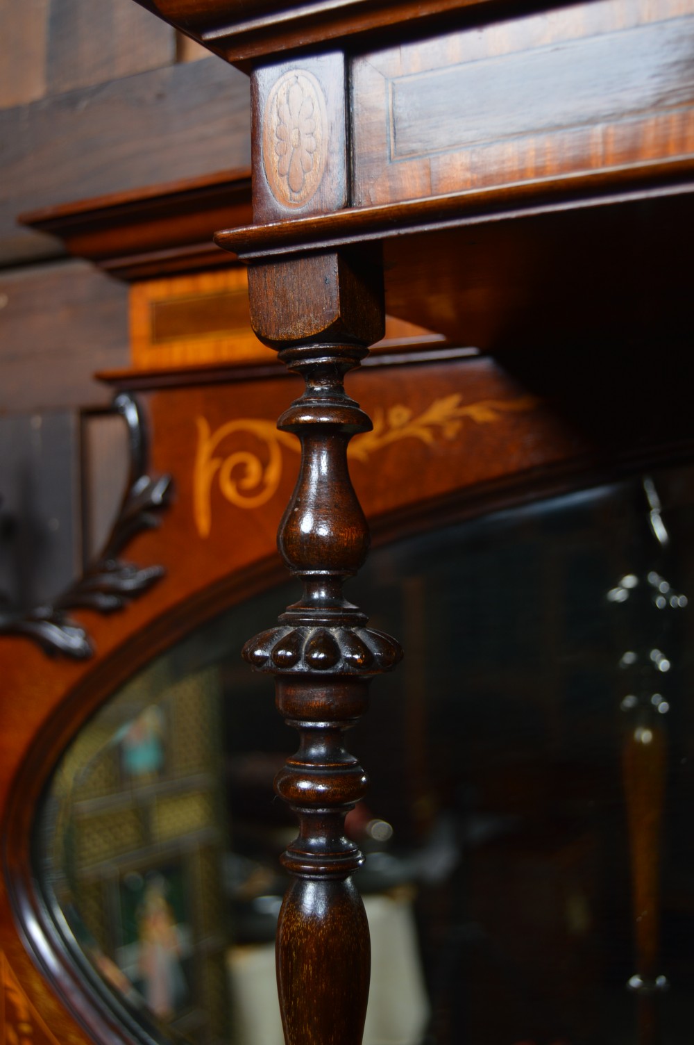 An Edwardian mahogany display cabinet featuring floral marquetry inlay, an oval mirror backdrop, astragal glazed central door, and slender cabriole legs. View XIV