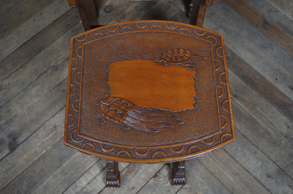 A set of four nested carved hardwood tables featuring intricate relief patterns on the tops and carved detailing along the legs. View XII