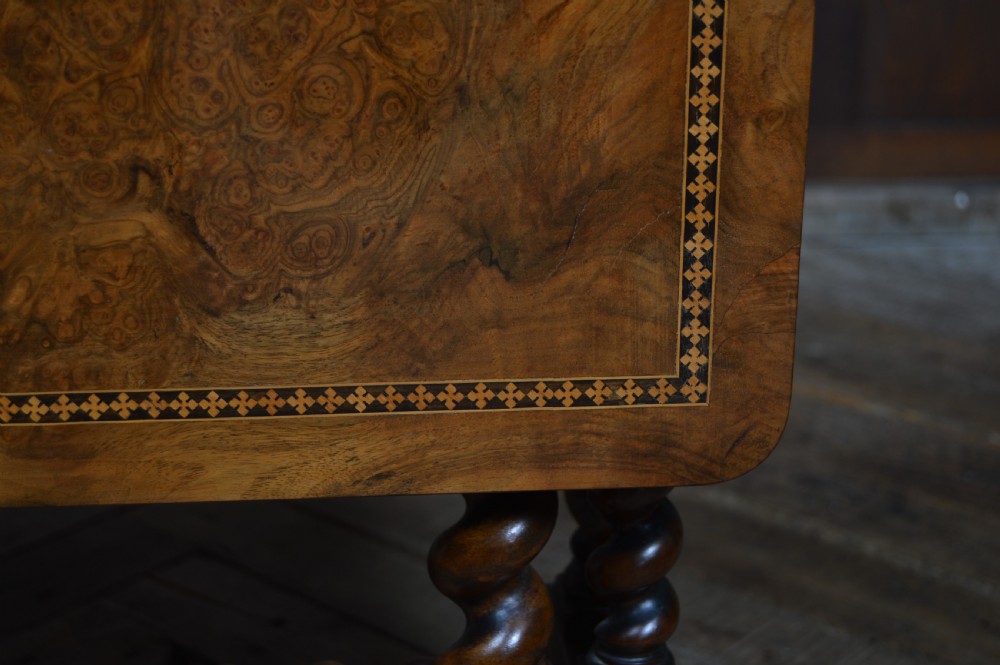 A Victorian burr walnut Sutherland drop-leaf table featuring inlaid geometric borders and barley twist legs on brass castors. View IX