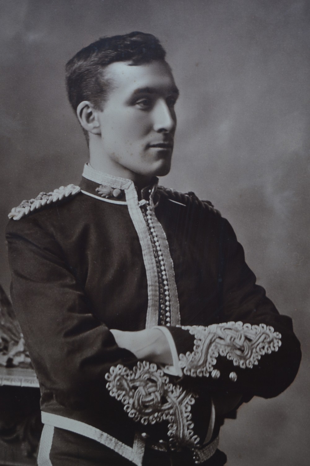 A monochrome photographic portrait of a male military officer in uniform, displayed within a cream mount, gilt slip, and dark moulded oak frame. View III