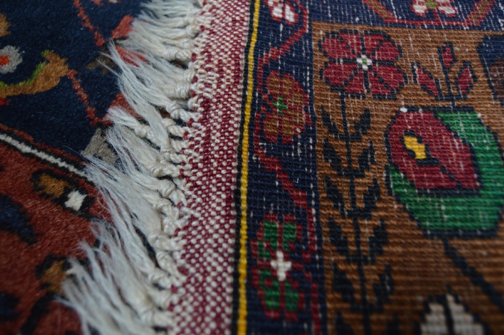 A long hand-knotted Turkish rug runner featuring a central light grey and blue geometric medallion on a terracotta red field, framed by dark navy spandrels and a multi-band decorative border. View X