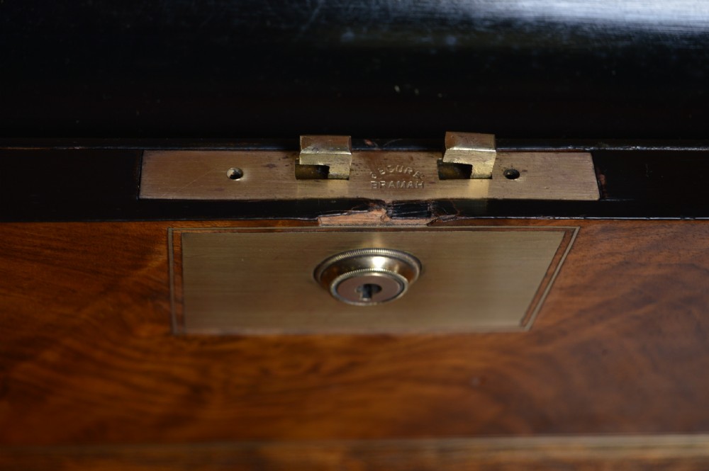 A closed rectangular Victorian burr walnut writing slope featuring metal border trim, a keyhole escutcheon, and an engraved metal presentation plaque on top. View VII
