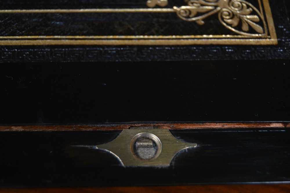 A closed rectangular Victorian burr walnut writing slope featuring metal border trim, a keyhole escutcheon, and an engraved metal presentation plaque on top. View XI
