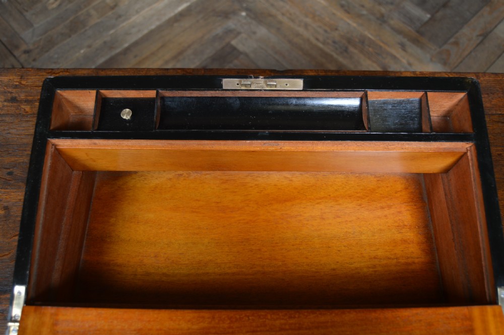 A closed rectangular Victorian burr walnut writing slope featuring metal border trim, a keyhole escutcheon, and an engraved metal presentation plaque on top. View XIV