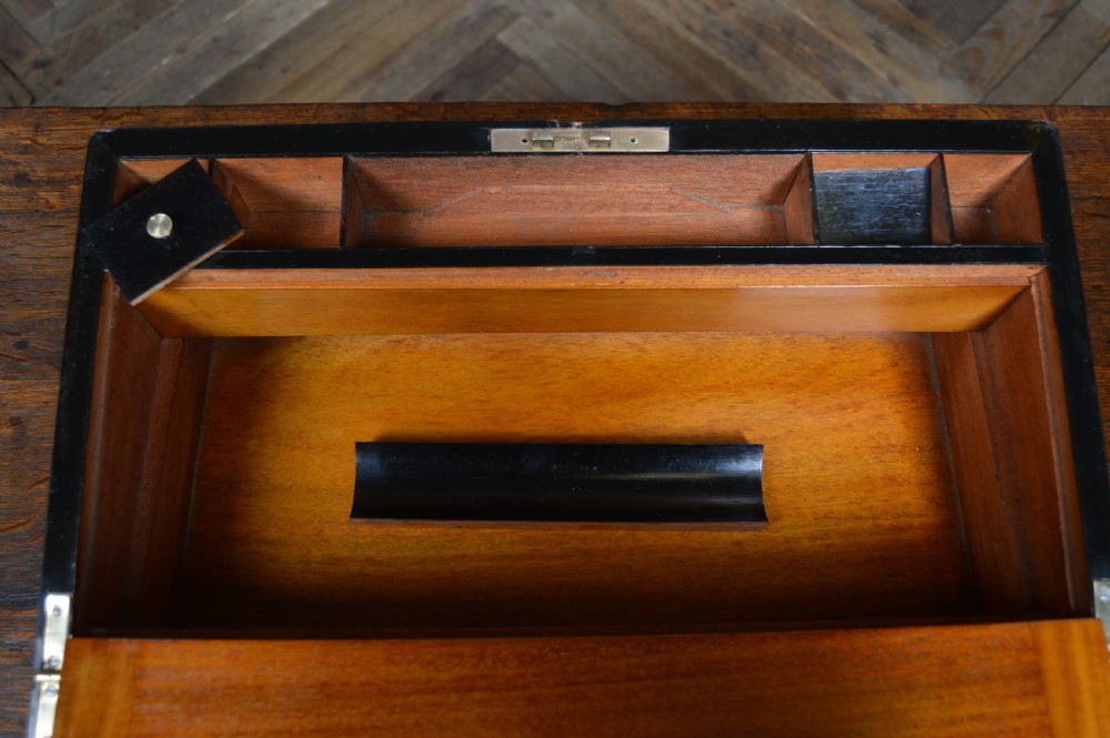 A closed rectangular Victorian burr walnut writing slope featuring metal border trim, a keyhole escutcheon, and an engraved metal presentation plaque on top. View XV