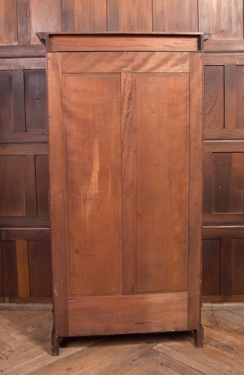 An Edwardian mahogany glazed bookcase featuring geometric astragal glazing, carved corner spandrels, and bottom drawers with drop handles. View XX