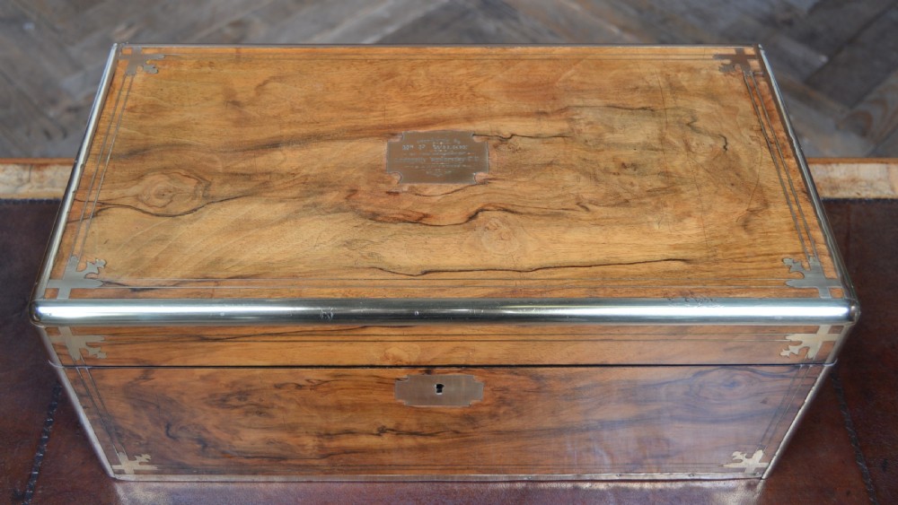 A closed Victorian burr walnut writing slope featuring brass corner straps, stringing inlay, and a brass keyhole escutcheon. View VII