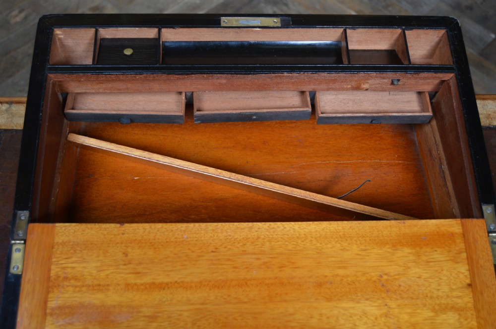 A closed Victorian burr walnut writing slope featuring brass corner straps, stringing inlay, and a brass keyhole escutcheon. View XVIII
