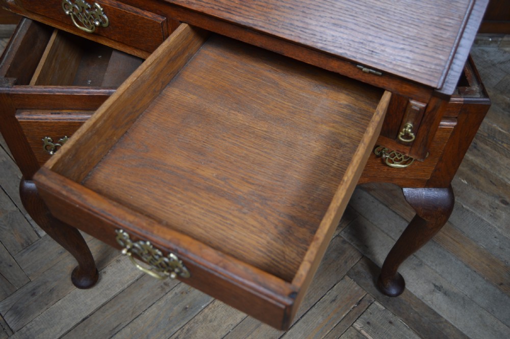 An Edwardian oak slant-front bureau on stand featuring brass drop handles, a shaped lower apron, and four cabriole legs ending in pad feet. View XIII