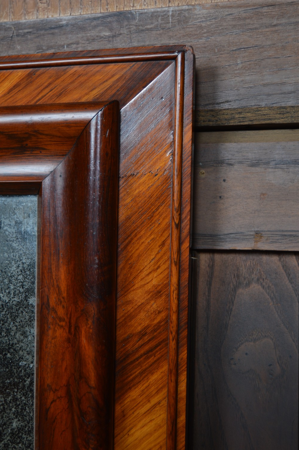 A rectangular antique wall mirror featuring a rich rosewood and kingwood crossbanded timber frame with distressed mirror glass. View II