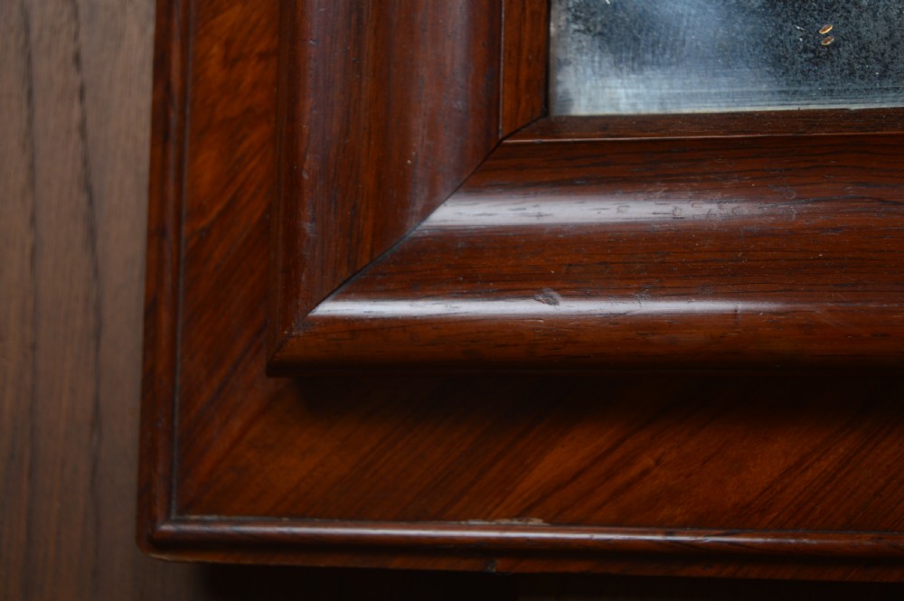 A rectangular antique wall mirror featuring a rich rosewood and kingwood crossbanded timber frame with distressed mirror glass. View IV