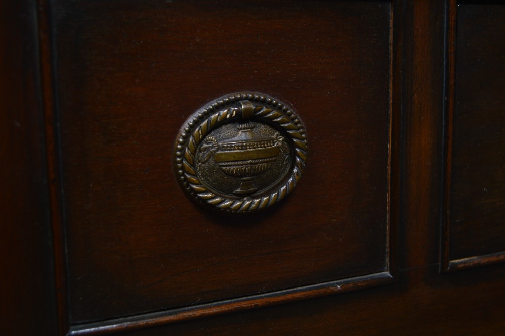 An Edwardian mahogany corner cabinet featuring astragal glazed upper doors, blind fretwork frieze, a single lower drawer, and cabriole legs ending in pad feet. View III