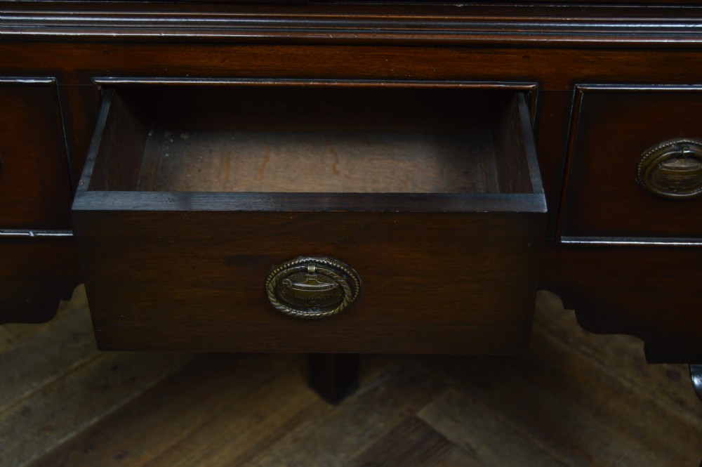 An Edwardian mahogany corner cabinet featuring astragal glazed upper doors, blind fretwork frieze, a single lower drawer, and cabriole legs ending in pad feet. View IX