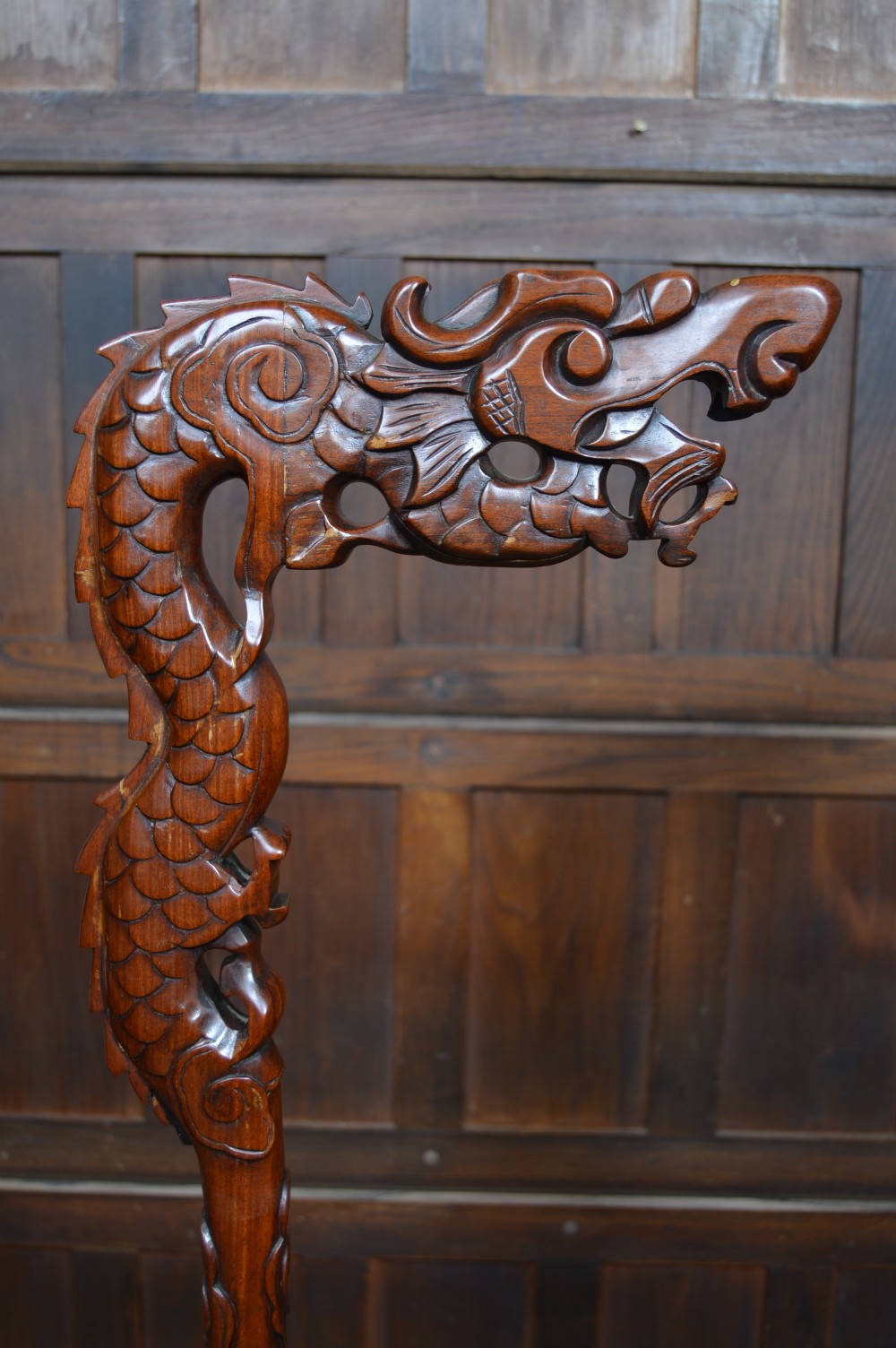 A pair of tall carved hardwood Chinese lantern stands featuring carved dragon head finials, open fretwork, and circular bases. View V
