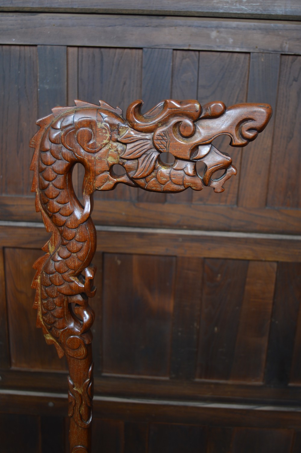 A pair of tall carved hardwood Chinese lantern stands featuring carved dragon head finials, open fretwork, and circular bases. View VI