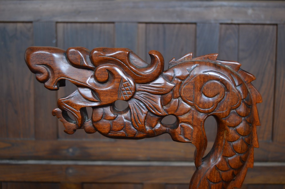 A pair of tall carved hardwood Chinese lantern stands featuring carved dragon head finials, open fretwork, and circular bases. View X