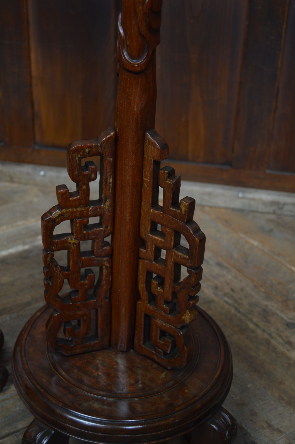 A pair of tall carved hardwood Chinese lantern stands featuring carved dragon head finials, open fretwork, and circular bases. View XII