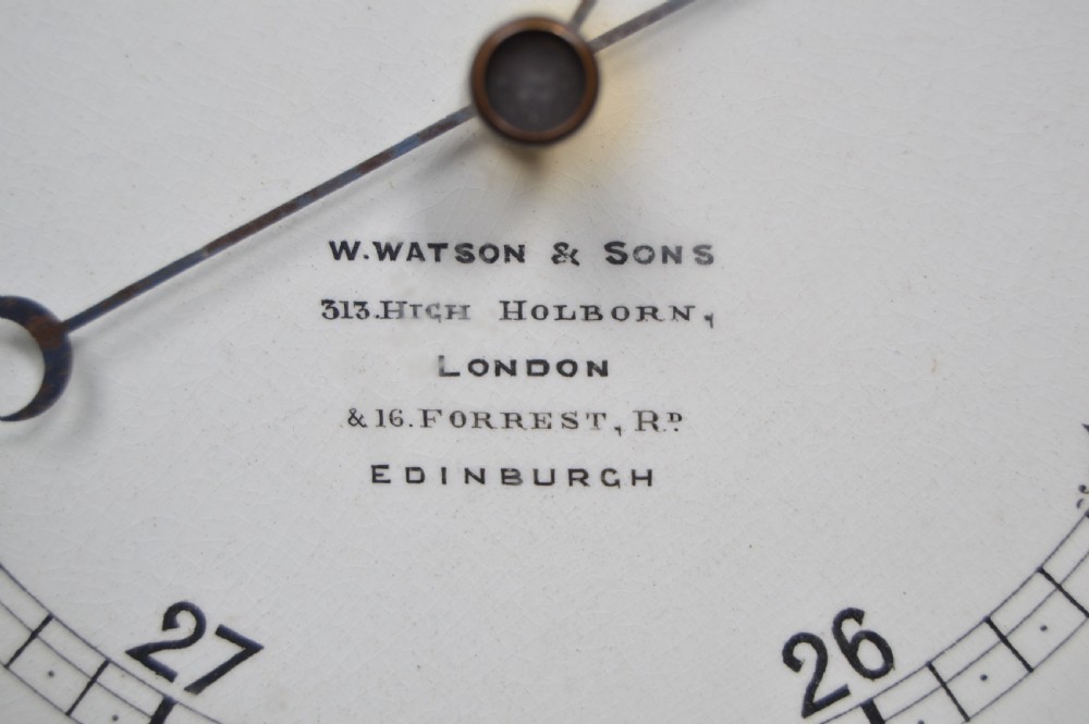 A carved oak Victorian aneroid wall barometer featuring an upper spirit thermometer scale and a lower circular pressure dial. View VIII