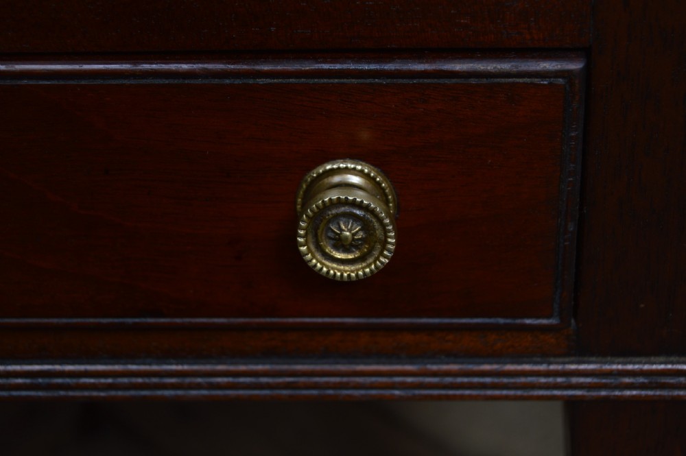 A 19th-century mahogany Canterbury featuring four vertical slatted compartments, a central cut-out handle, a single base drawer with brass knobs, and tapered legs on brass castors. View VI