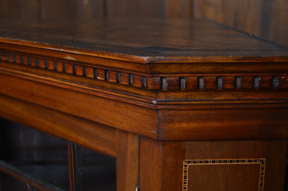 An Edwardian mahogany wall-hanging corner cabinet featuring an astragal glazed single door with diamond pattern glazing bars, dentil moulding, and satinwood string inlay. View II