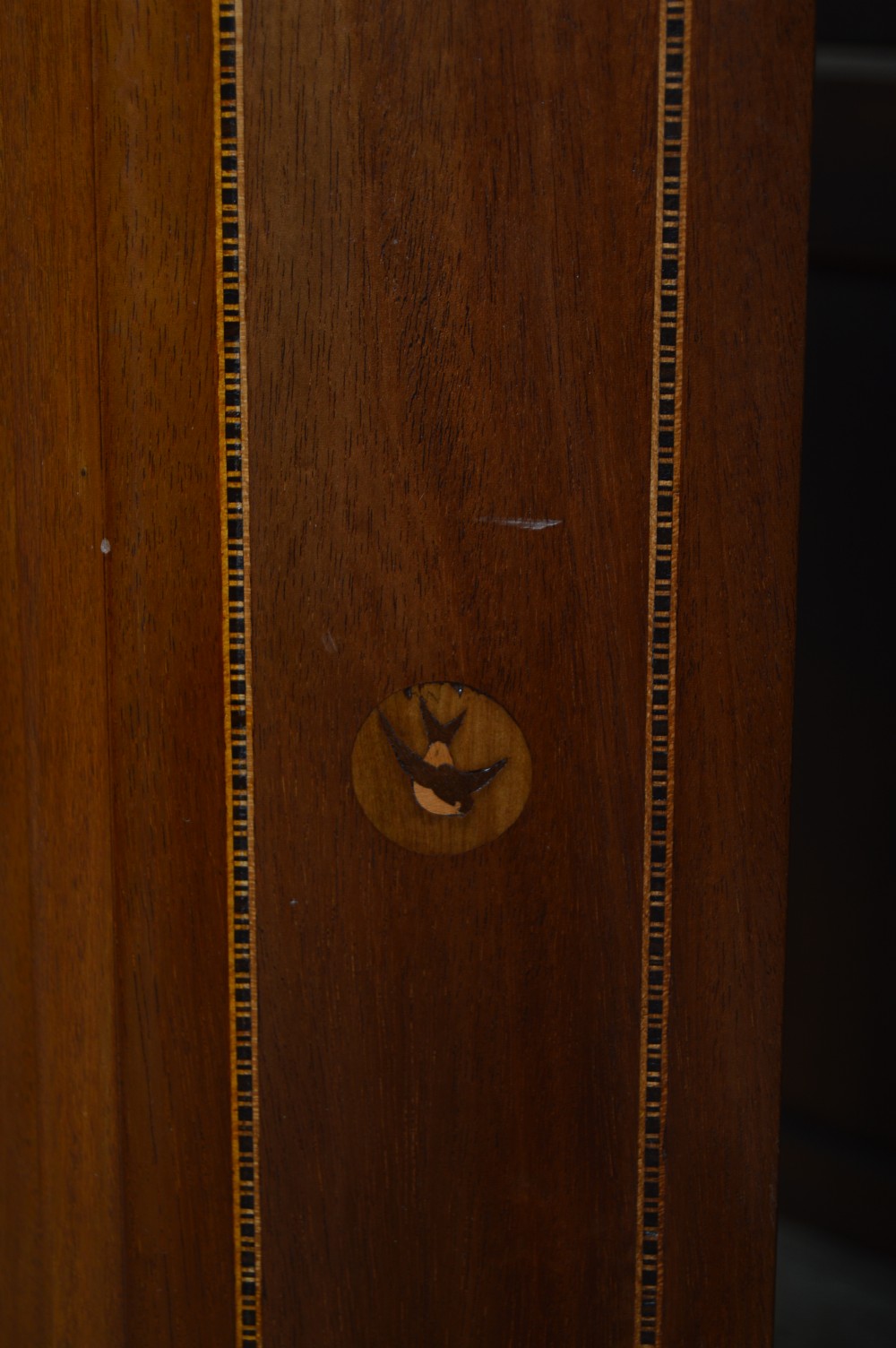An Edwardian mahogany wall-hanging corner cabinet featuring an astragal glazed single door with diamond pattern glazing bars, dentil moulding, and satinwood string inlay. View III