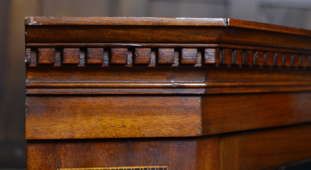 An Edwardian mahogany wall-hanging corner cabinet featuring an astragal glazed single door with diamond pattern glazing bars, dentil moulding, and satinwood string inlay. View X