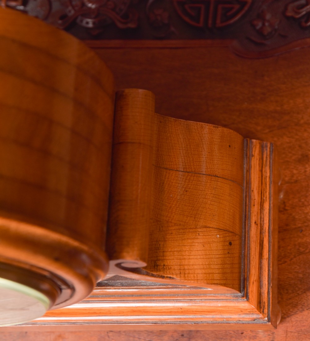 An antique oak mantel clock featuring a rounded arch case, brass dial with Roman numerals, marked Thwaites and Reed London, raised on brass bun feet. View VII