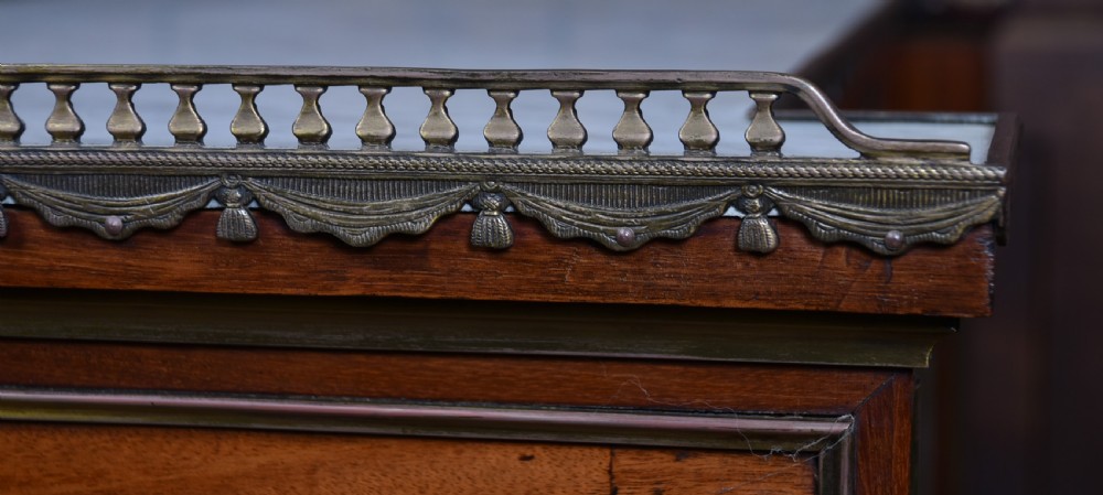 A French mahogany glazed bookcase featuring two glass-panelled doors, brass mounts, fluted side columns, and a light marble top. View XIV